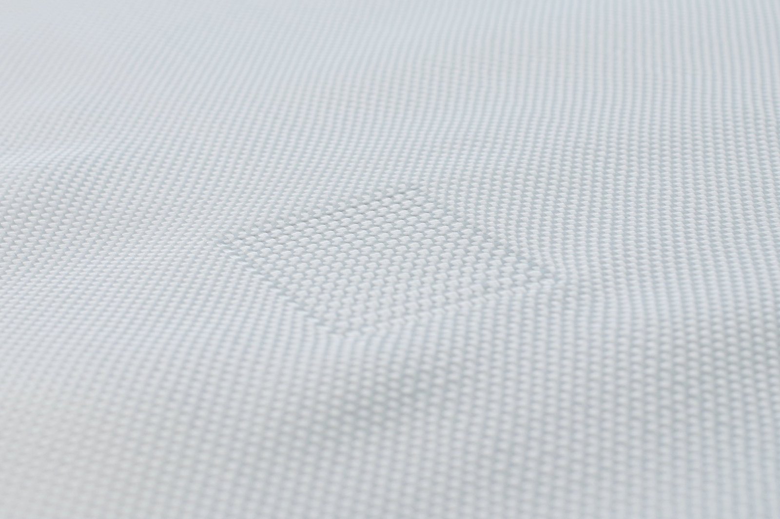 Close-up view of a geotextile mattress showing its textured surface made of synthetic fibers. The woven fabric displays a subtle pattern, emphasizing the material's strength and durability important for civil engineering applications. Ideal for erosion control and landscaping projects.